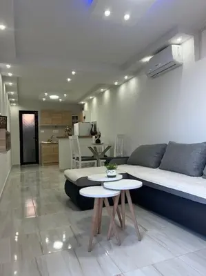 a living room with a couch and two tables at Studio apartman Gara in Kotor