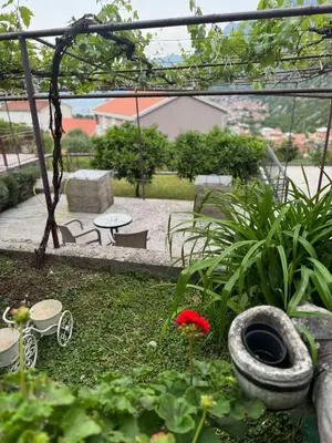 a garden with a tire and a table and chairs at Studio apartman Gara in Kotor