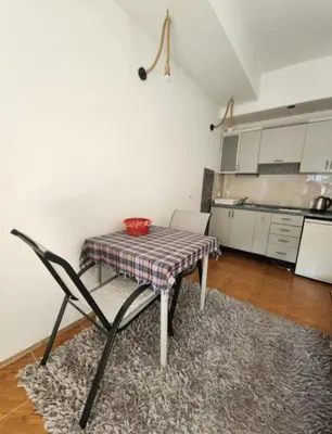 a table and chair in a room with a kitchen at Apartments Ksenija in Kotor