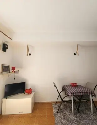 a living room with a table and a chair at Apartments Ksenija in Kotor