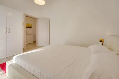 a white bedroom with two white beds in it at Sky Fort Apartment in Dobra Voda
