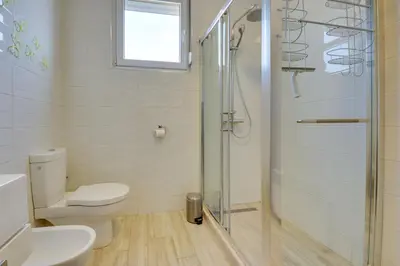 a bathroom with a toilet and a glass shower at Sky Fort Apartment in Dobra Voda