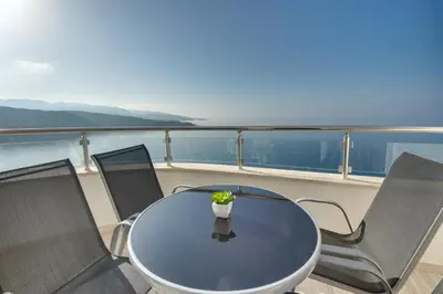 a table and chairs on a balcony on a yacht at Sky Fort Apartment in Dobra Voda