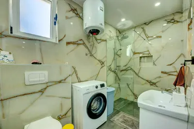 a bathroom with a washing machine and a sink at Hamburg in Utjeha
