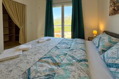 a bedroom with a large bed with a window at Penthouse Sunce in Dobra Voda