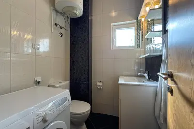 a bathroom with a washing machine and a sink at Penthouse Sunce in Dobra Voda