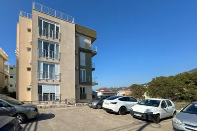 a group of cars parked in a parking lot in front of a building at Penthouse Sunce in Dobra Voda