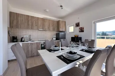 a kitchen and dining room with a table and chairs at Penthouse Sunce in Dobra Voda