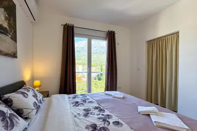 a bedroom with a bed and a large window at Penthouse Sunce in Dobra Voda