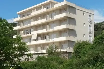 a tall white building with trees in front of it at Sunset Penthouse in Utjeha