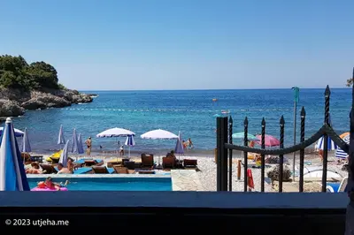 a beach with chairs and umbrellas and the ocean at Sunset Penthouse in Utjeha