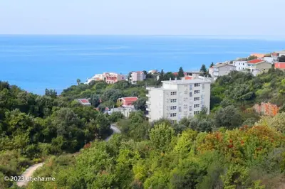 a building on a hill next to the ocean at Sunset Penthouse in Utjeha