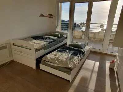 two beds in a bedroom with a balcony at Sunset Penthouse in Utjeha
