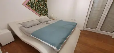 a white bed with a blue blanket on top of it at Sunset Penthouse in Utjeha