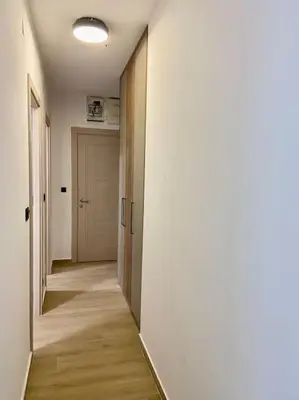 an empty hallway with a door and a hallwayngth at Modern 2BR Apt in Rafailovići - Near the Beach in Budva