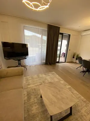 a living room with a couch and a flat screen tv at Modern 2BR Apt in Rafailovići - Near the Beach in Budva