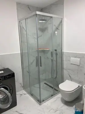 a bathroom with a glass shower with a toilet at Modern 2BR Apt in Rafailovići - Near the Beach in Budva