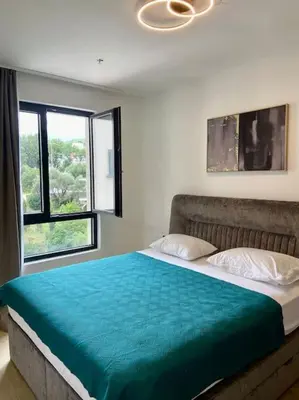 a bedroom with a large bed with a large window at Modern 2BR Apt in Rafailovići - Near the Beach in Budva