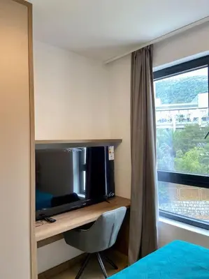 a bedroom with a desk with a tv and a window at Modern 2BR Apt in Rafailovići - Near the Beach in Budva