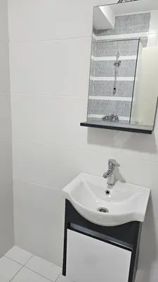 a white bathroom with a sink and a mirror at Lamela B in Podgorica