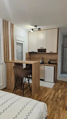 a kitchen with a table and a chair in a room at Lamela B in Podgorica