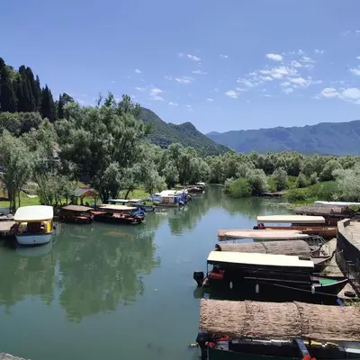 a group of boats are docked on a river at Woodhouse Maja in Virpazar