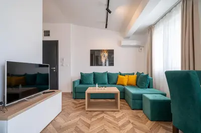 a living room with a blue couch and a tv at Sun and Sea Apartments in Budva