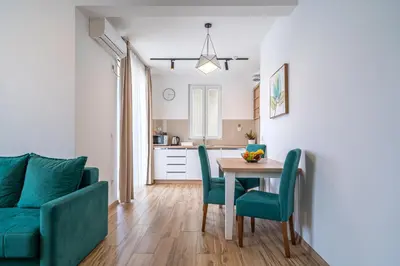 a kitchen and dining room with a table and chairs at Sun and Sea Apartments in Budva