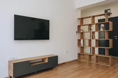 a living room with a flat screen tv and a book shelf at Top27 in Budva