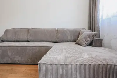 a gray couch in a living room next to a window at Top27 in Budva