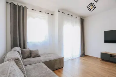 a living room with a couch and two large windows at Top27 in Budva