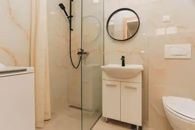 a bathroom with a shower and a sink and a mirror at Top27 in Budva