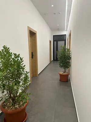 a corridor with two potted plants in a hallway at Avio Apartments in Podgorica