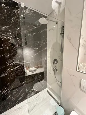 a bathroom with a shower with a glass door at Avio Apartments in Podgorica