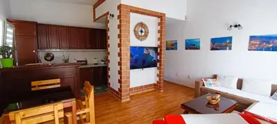 a kitchen and living room with a clock on the wall at Apartment Matko Budva in Budva