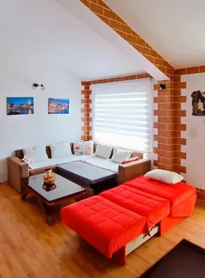 a living room with a couch and a red bench at Apartment Matko Budva in Budva