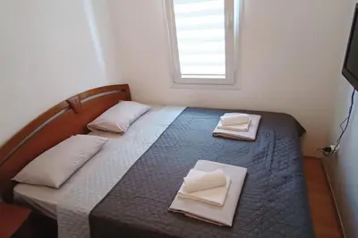 a bedroom with a bed with two pillows and a window at Apartment Matko Budva in Budva