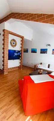 a living room with a bed and a brick wall at Apartment Matko Budva in Budva