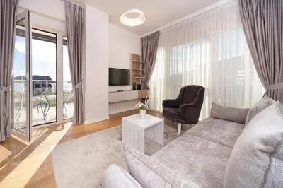 a living room with a couch and a tv at Tre canne cozy sea view apartment in Budva