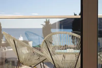 a couple of chairs sitting on a balcony at Tre canne cozy sea view apartment in Budva