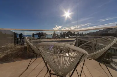 a pair of chairs sitting on top of a balcony at Tre canne cozy sea view apartment in Budva