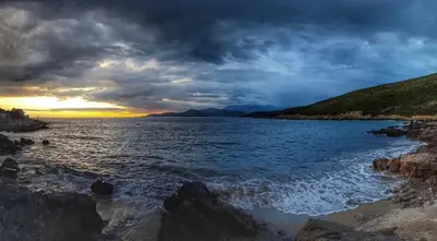 a sunset over a body of water with rocks at Villa Symphony apartments Kotor Tivat in Kotor