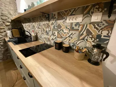 a kitchen with a counter with a patterned wall at Cevna River in Podgorica