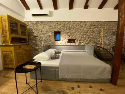 a bedroom with a bed and a stone wall at Cevna River in Podgorica