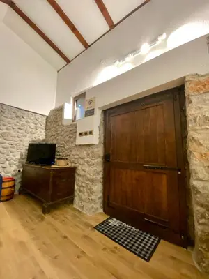 a large wooden door in a room with a stone wall at Cevna River in Podgorica