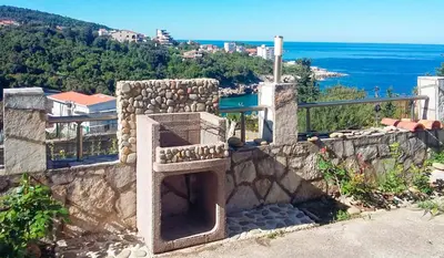 a stone wall with a stone oven with a view of the ocean at Villa Blanca in Utjeha