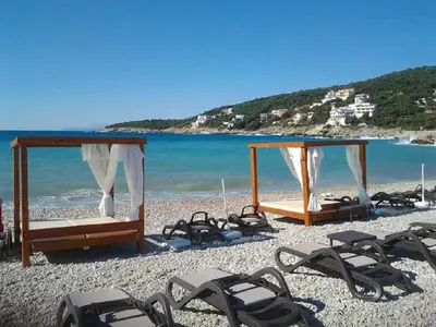 a group of chairs and beds on a beach at Villa Blanca in Utjeha