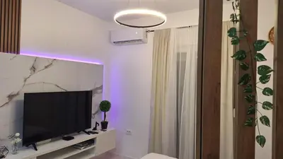 a living room with a flat screen tv sitting on a shelf at Ella Lux Apartment in Podgorica