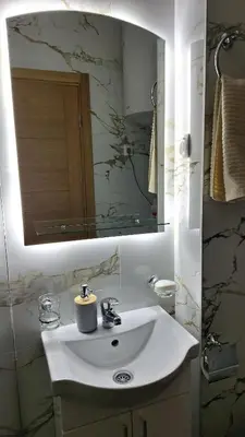 a bathroom with a white sink and a mirror at Ella Lux Apartment in Podgorica