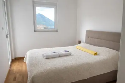 a bed with two towels on it with a window at Apartment Jana Meerblick mit Balkon nähe Sandstrand in Becici